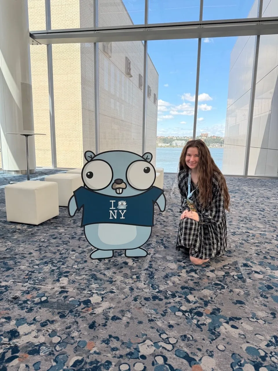 Bethany squats next to a gopher wearing an I "gopher" NY t-shirt, which is a play on the typical I heart NY t-shirt.